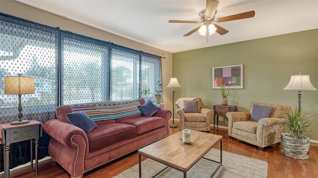 living room featuring ceiling fan, wood finished floors, and baseboards