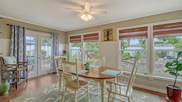 dining space with wainscoting, ceiling fan, a decorative wall, and tile patterned floors