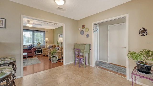 foyer entrance with visible vents, ceiling fan, baseboards, and light tile patterned floors