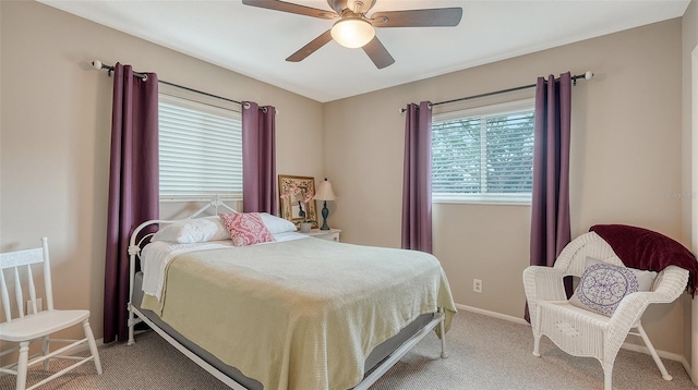 bedroom featuring light carpet, a ceiling fan, and baseboards