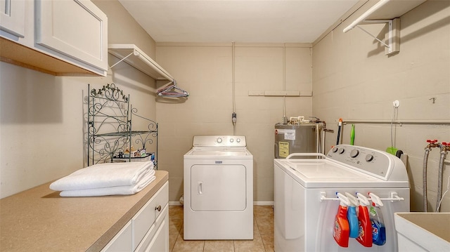 washroom with cabinet space, light tile patterned floors, washer and clothes dryer, water heater, and a sink