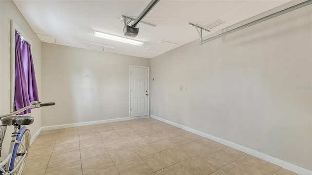 garage featuring a garage door opener and baseboards