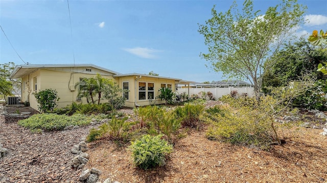 rear view of property featuring central AC and fence