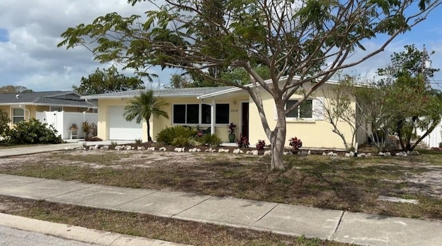 single story home with concrete driveway, fence, an attached garage, and stucco siding