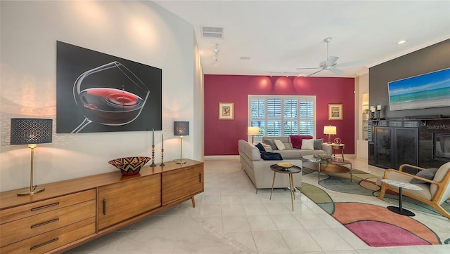 living room with baseboards, track lighting, visible vents, and a ceiling fan