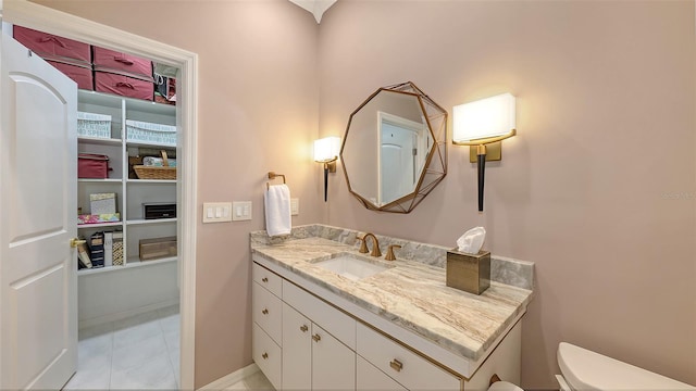 bathroom featuring toilet, baseboards, and vanity