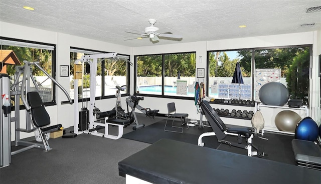 gym with a ceiling fan, visible vents, and a textured ceiling