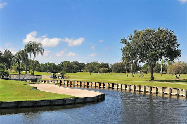 view of community featuring a water view, a yard, and golf course view