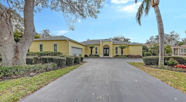 view of front of home featuring a garage, concrete driveway, and stucco siding