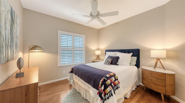 bedroom with ceiling fan, baseboards, and wood finished floors