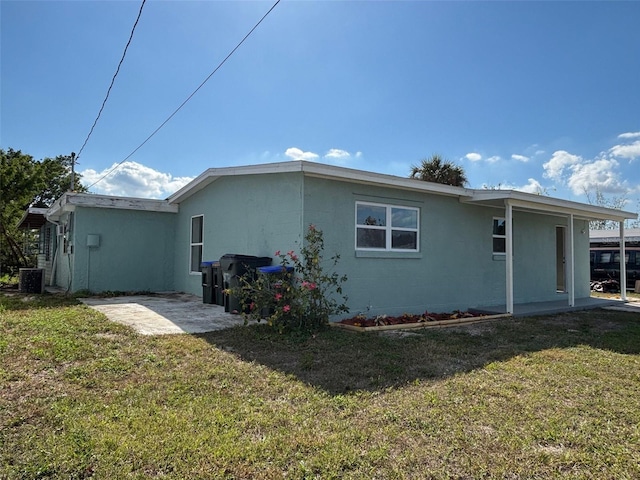 view of side of property with central AC, a yard, and a patio area