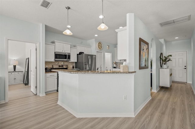 8956 Stone Harbour Loop, Bradenton, FL 34212 - kitchen featuring visible vents, white cabinets, light wood finished floors, appliances with stainless steel finishes, and backsplash