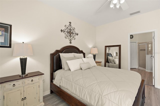8956 Stone Harbour Loop, Bradenton, FL 34212 - bedroom featuring baseboards, ensuite bath, light wood-style flooring, and visible vents