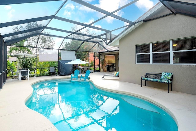 view of pool with a patio and glass enclosure