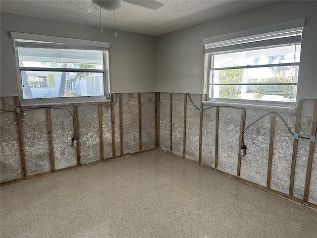 spare room with a ceiling fan, a textured ceiling, and speckled floor