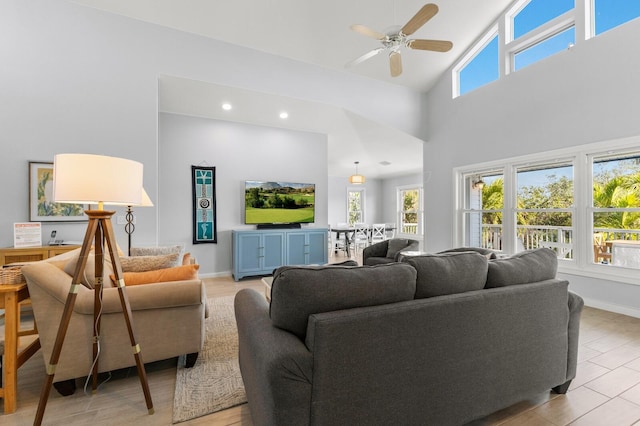 living area with high vaulted ceiling, recessed lighting, a ceiling fan, and baseboards