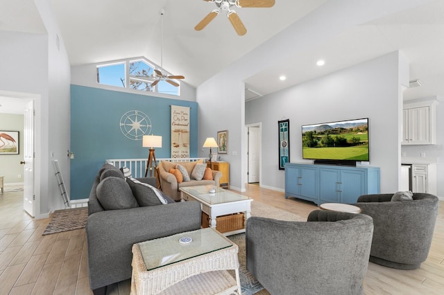 living area with light wood finished floors, visible vents, baseboards, a ceiling fan, and high vaulted ceiling