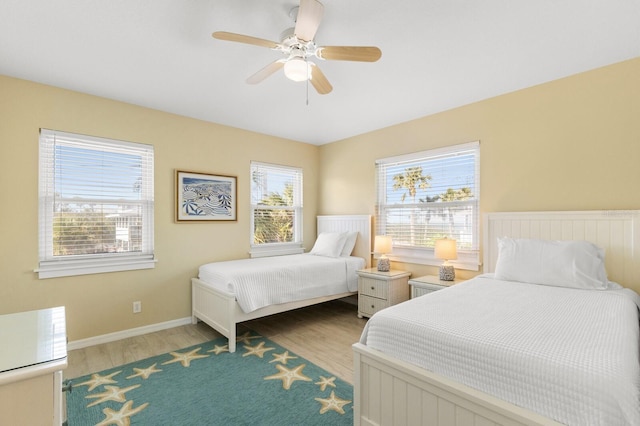 bedroom with ceiling fan, baseboards, and wood finished floors