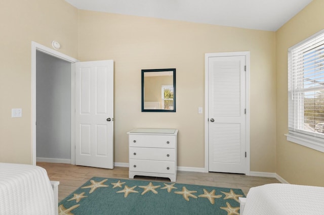 bedroom with light wood-style flooring and baseboards