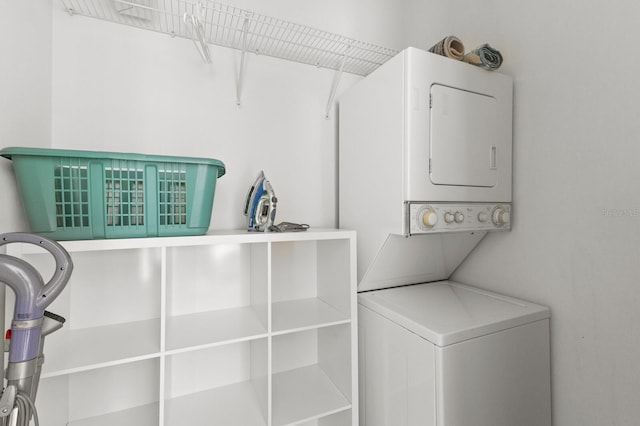 washroom with stacked washer and dryer and laundry area