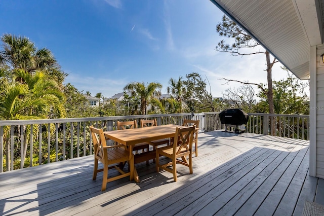 wooden deck with outdoor dining area and a grill