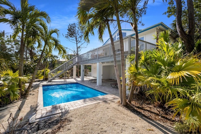 pool featuring a patio area, stairs, and a deck