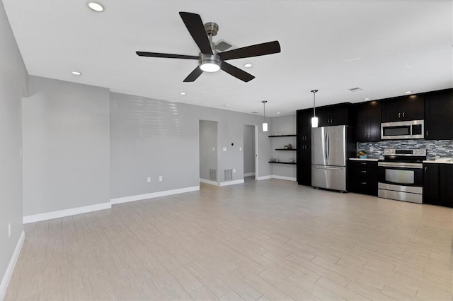 kitchen with tasteful backsplash, light wood-type flooring, appliances with stainless steel finishes, pendant lighting, and ceiling fan