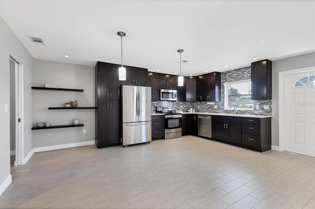 kitchen with tasteful backsplash, sink, hanging light fixtures, stainless steel appliances, and dark brown cabinets
