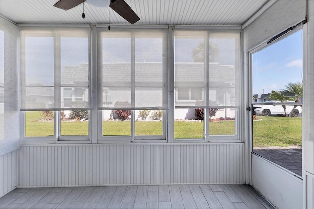 unfurnished sunroom with ceiling fan
