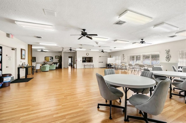 dining area with a textured ceiling and light wood-type flooring