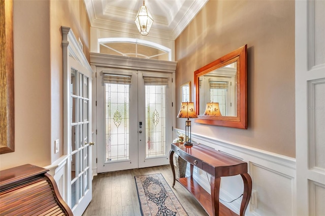 foyer with wainscoting, ornamental molding, hardwood / wood-style floors, and french doors