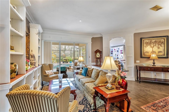 living area with a baseboard radiator, visible vents, dark wood finished floors, and ornamental molding