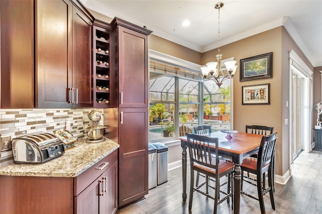 interior space featuring baseboards, light wood finished floors, and crown molding