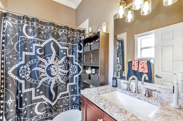 bathroom with toilet, ornamental molding, and vanity