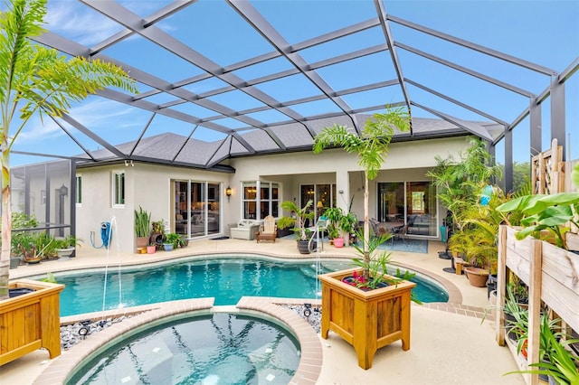 back of house featuring a lanai, a patio area, and stucco siding