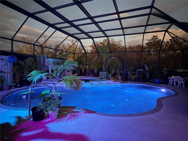 pool at dusk with a lanai, an outdoor pool, a hot tub, and a patio