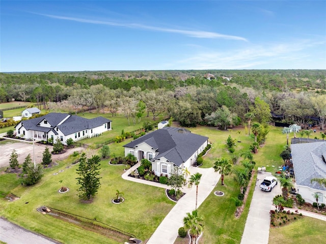 drone / aerial view featuring a residential view and a view of trees