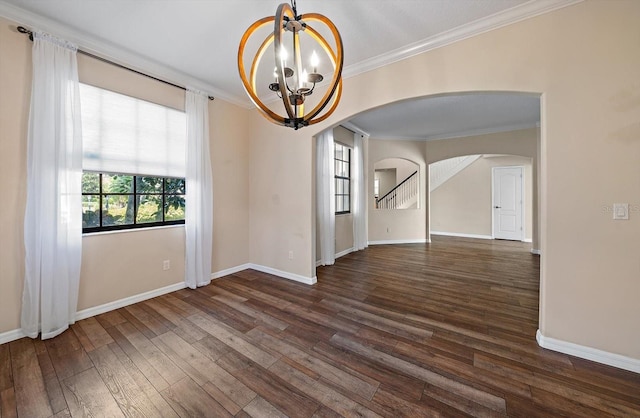 unfurnished room with baseboards, arched walkways, wood finished floors, crown molding, and a notable chandelier