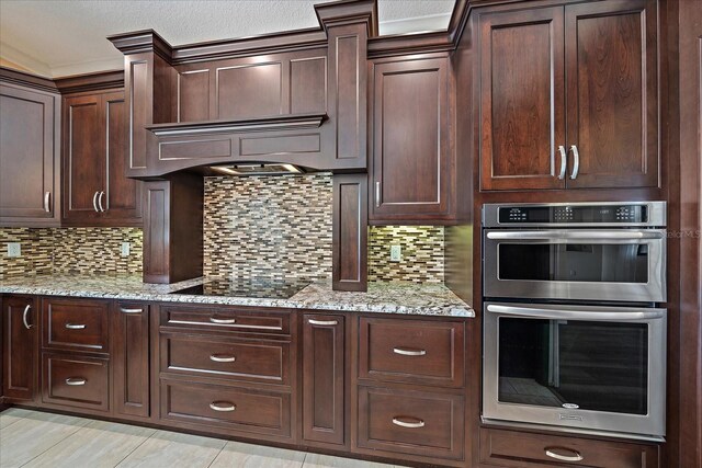 kitchen with double oven, dark brown cabinetry, backsplash, and black electric cooktop