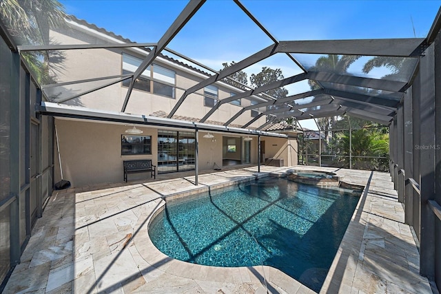 view of swimming pool featuring a pool with connected hot tub, a patio area, and a lanai