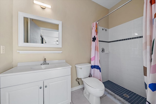 bathroom featuring vanity, a tile shower, toilet, and tile patterned floors