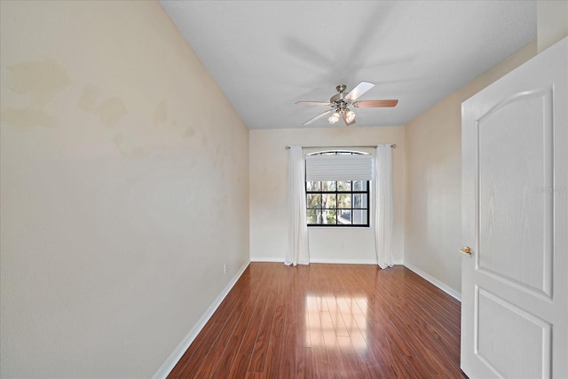 spare room with ceiling fan, wood finished floors, and baseboards