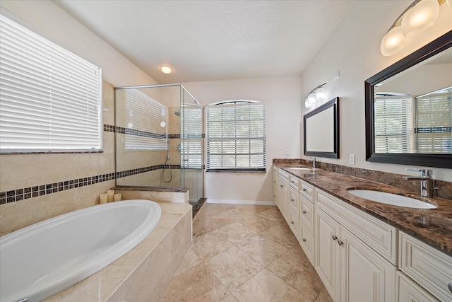 bathroom with a garden tub, double vanity, a sink, and a shower stall