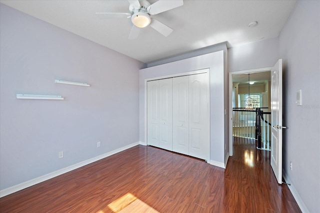 unfurnished bedroom with a ceiling fan, a closet, baseboards, and wood finished floors