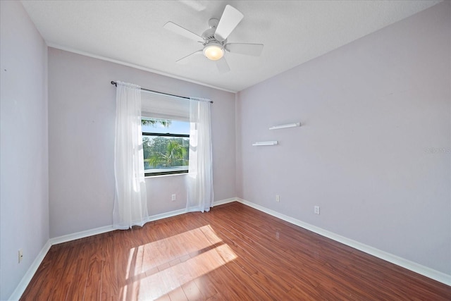 unfurnished room featuring a ceiling fan, baseboards, and wood finished floors