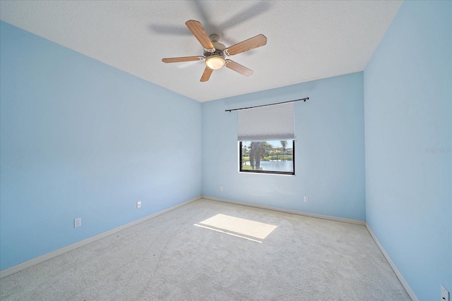 empty room with a textured ceiling, carpet floors, and baseboards