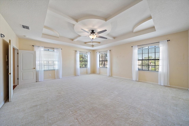 carpeted spare room featuring visible vents, ceiling fan, a textured ceiling, and baseboards