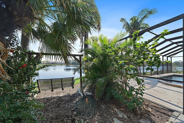 exterior space with a lanai, a water view, a patio area, and an outdoor pool