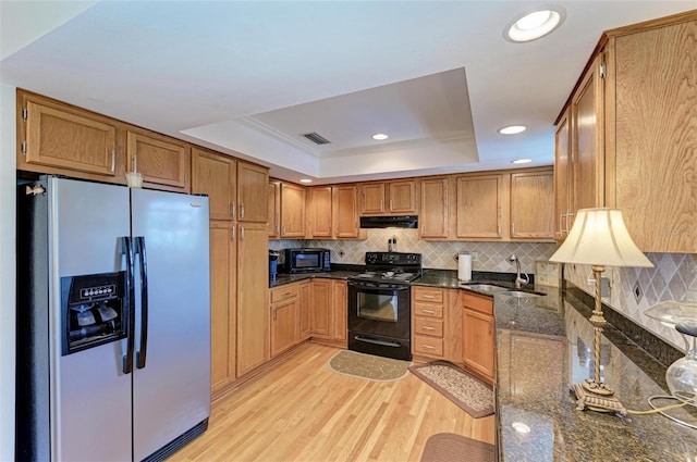 kitchen with visible vents, a sink, a raised ceiling, black appliances, and extractor fan