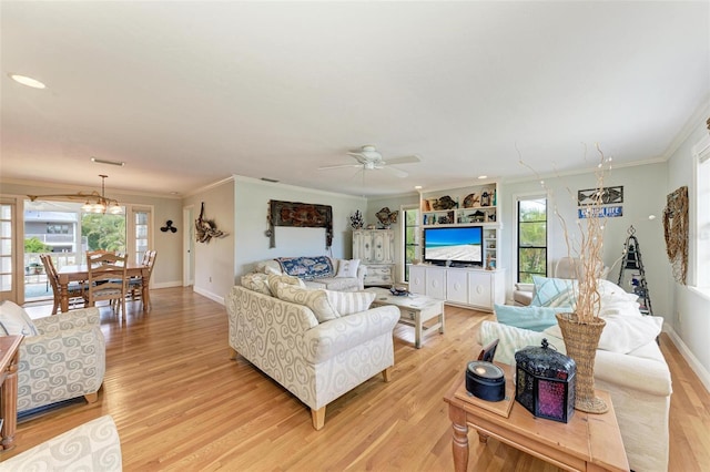 living area with crown molding, ceiling fan with notable chandelier, and light wood-type flooring